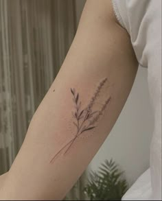 a woman's arm with a small flower tattoo on the left side of her arm