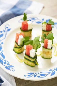 cucumber and cheese appetizers on a blue and white plate