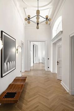 an empty hallway with white walls and wood flooring