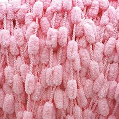 the pink fabric is covered with tiny beads and chains, as if it were made from cotton