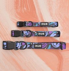 three black and purple dog collars with the words em & me printed on them