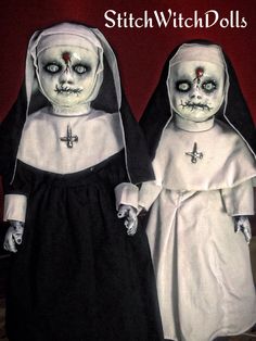 two dolls dressed in white and black are standing next to each other