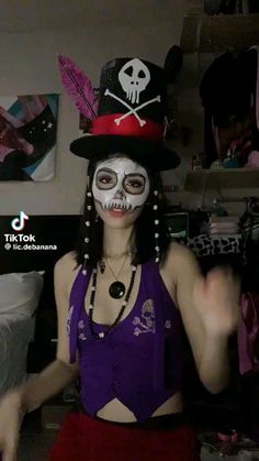 a woman with white makeup and skeleton make up on her face wearing a top hat