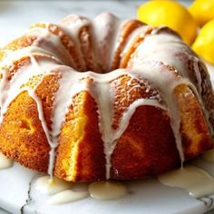 a bundt cake with icing and lemons in the background