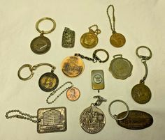 many different types of key chains and pendants on a white surface, including one with an american flag