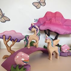 wooden toy horses and trees with butterflies on the wall