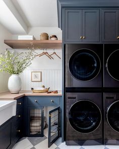 a washer and dryer in a laundry room with blue cabinets, checkered floor