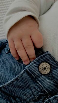 a close up of a person's hand on the pocket of a pair of jeans