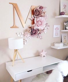 a white desk with pink flowers on it and a wooden letter m above the desk