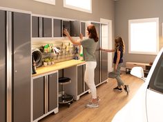 two women are standing in front of some cabinets