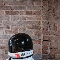 a white and black helmet on top of a wooden table next to a brick wall