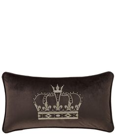 a brown pillow with a crown on the front and side, sitting on a white surface