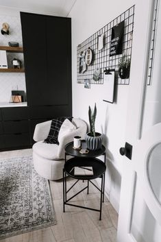 a living room with black and white decor on the walls, furniture and rugs