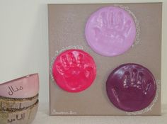 three handprints are on the wall next to two bowls