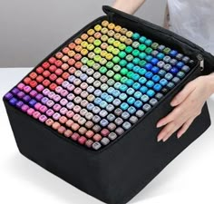 a person is holding a computer case with colorful keys on it's back side