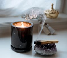 a black candle sitting on top of a white counter