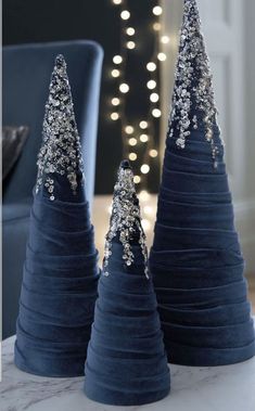 three blue christmas trees sitting on top of a table