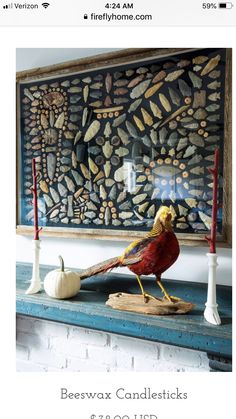 a bird sitting on top of a mantle next to candles