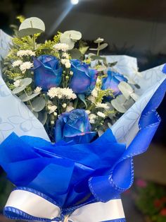 a bouquet of blue roses wrapped in paper