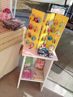 a table with many items on it and a yellow display case next to it that is filled with jewelry