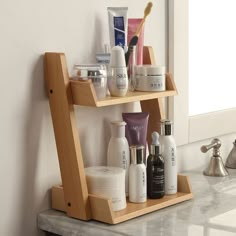 a wooden shelf with cosmetics and personal care items on it next to a bathroom sink