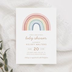 a rainbow baby shower is shown on top of a white sheet with greenery in the foreground