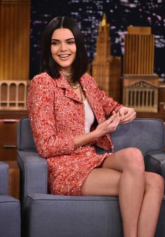 a woman sitting on top of a blue couch in front of a cityscape