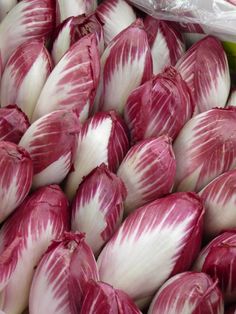 red and white onions are piled up in a pile for sale at the grocery store