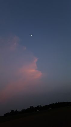 the moon is setting in the sky with clouds