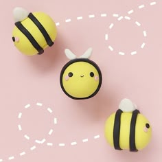 two small yellow and black bees on a pink surface with white circles in the background