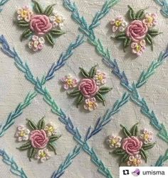 an embroidered fabric with flowers and leaves on the front, in pastel blue and pink colors