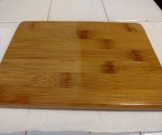 a wooden cutting board sitting on top of a white tiled counter