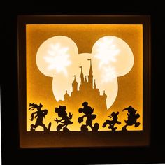 the silhouettes of mickey mouse and other disney characters in front of a castle at night