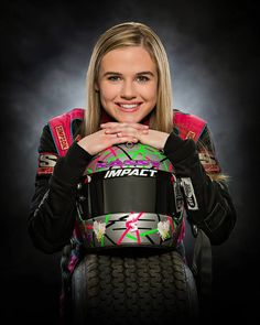 a woman holding a motorcycle helmet in her hands