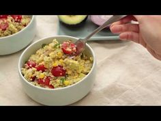 two bowls filled with food on top of a table next to an avocado