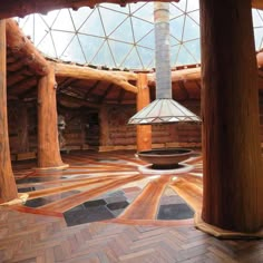 the inside of a log cabin with wood flooring and glass dome ceiling light fixture