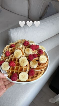 a waffle topped with bananas and raspberries