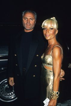 a man and woman standing next to each other in front of a car at an event