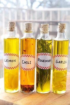 three bottles of lemon, rosemary and rosemary seed oil on a wooden table with a window in the background