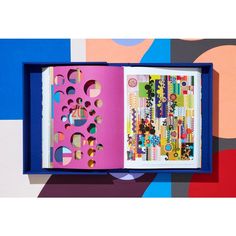 an open book with paper cutouts on the cover and inside is multicolored