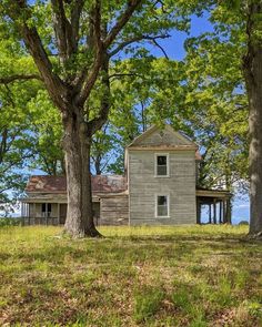 an old house sitting in the middle of some trees