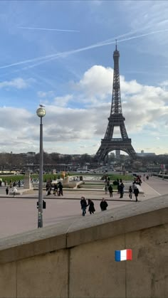 the eiffel tower towering over people walking around