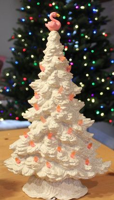 a small white christmas tree on top of a wooden table