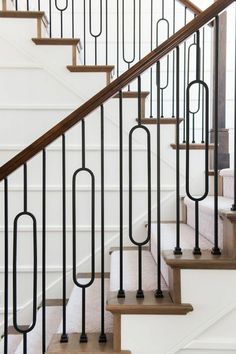 a set of stairs with black railings and white carpet