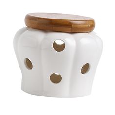 a white ceramic pot with wooden lid and holes in the bottom, on a white background