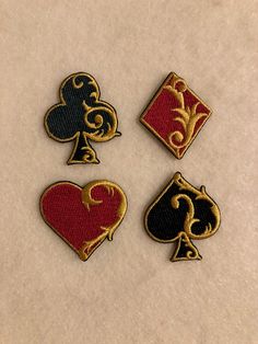 four different types of playing cards on a white tablecloth with gold and black border