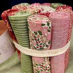 a stack of folded fabric sitting next to each other on top of a table covered in flowers