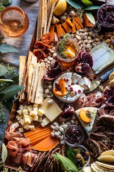 an assortment of cheeses, crackers and meats on a platter