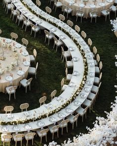 An artistic and innovative curved table setup for a wedding reception, surrounded by lush greenery. This unique arrangement offers intimacy and a touch of modernity to any event.