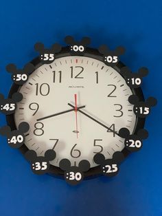 a clock with mickey mouse ears on it's face and numbers in the middle